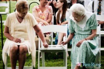 Two grandmothers look at a wedding ceremony program