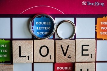 Wedding rings on a scrabble board spelling LOVE