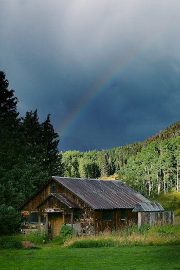 rainbow over a rustic cabin