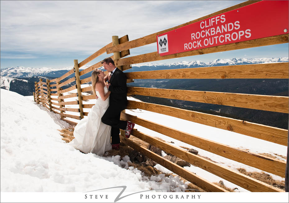 Bride and groom share a moment near snow fences at the top of the mountain