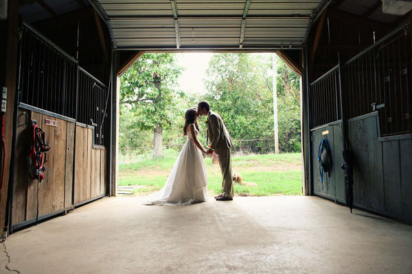Bride and Groom kiss in a barn