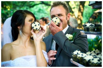 bride and groom pose with blueberry cupcakes