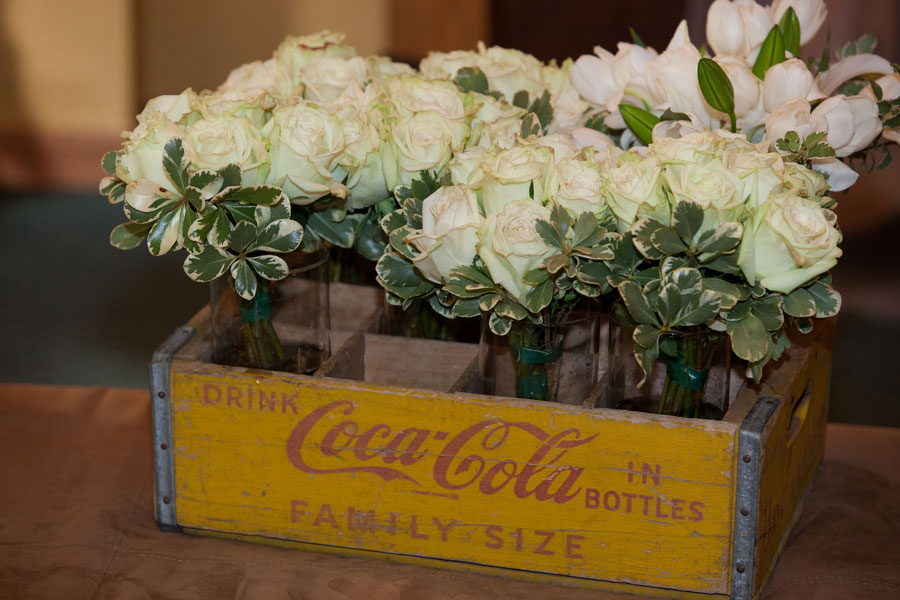 white roses in a vintage yellow and red coca-cola box