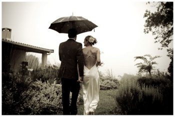 Black and white picture of a bride and groom in the rain