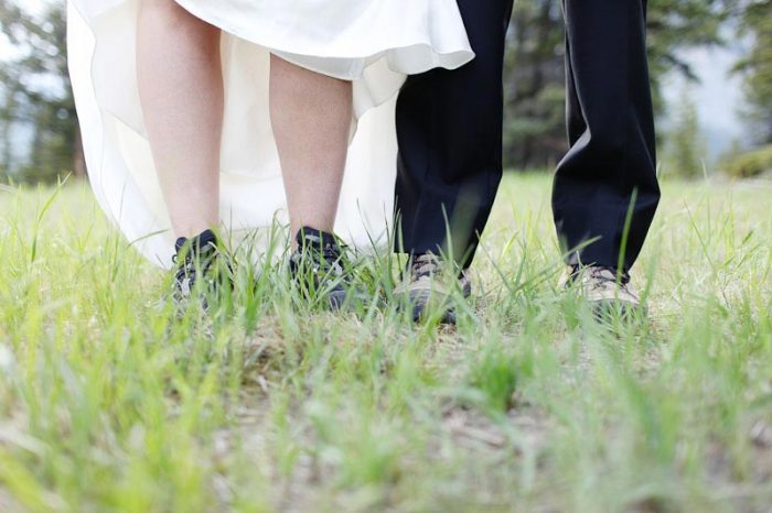 Bride and groom wearing hiking boots under their wedding attire in Banff