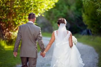 bride and groom walk hand in hand