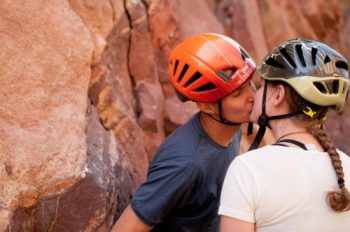 engaged rock climbers kiss