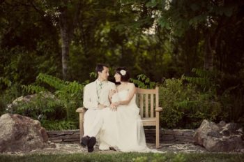 Hindsight Bride and groom sit on a garden bench