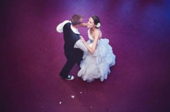 bride and groom dance on a purple dance floor