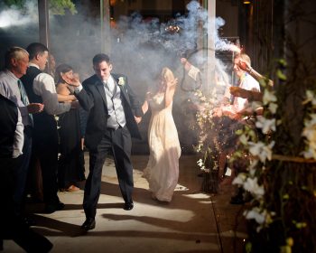 bride and groom exit in a cloud of smoke