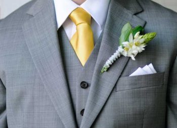 gold tie and green and white boutonnier