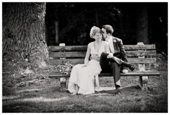 bride and groom on a park bench