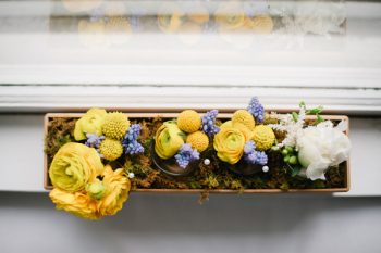 yellow flowers in a wooden flower box