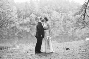 black and white bride and groom by a lake