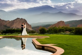 bride and groom kiis in front of mountains