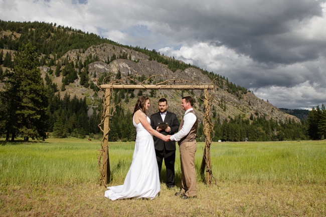 bride and grom marry under a handmade arbor