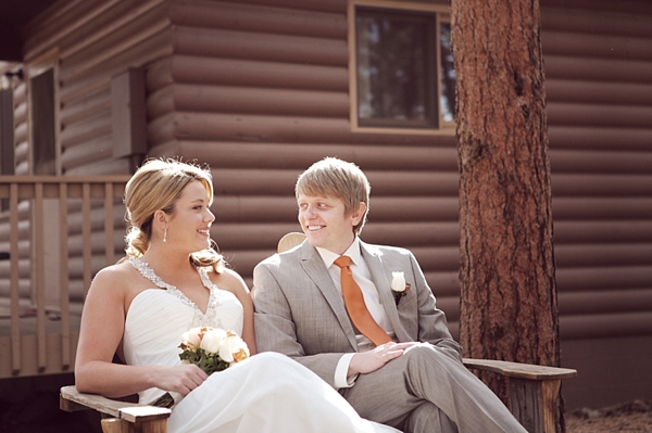 estes park bride and groom share a moment on a wooden bench