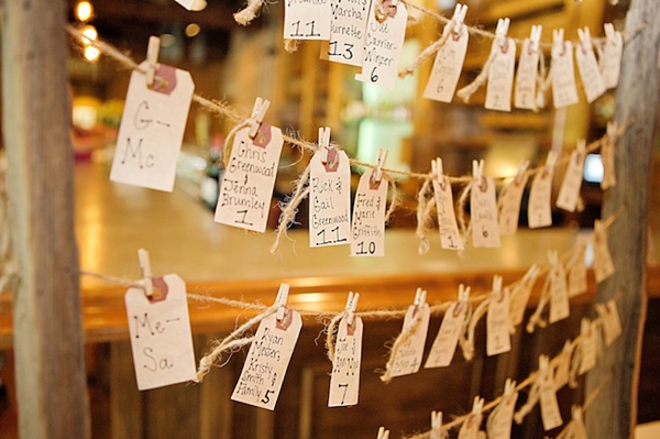 escort cards hanging from a vintage wooden window frame