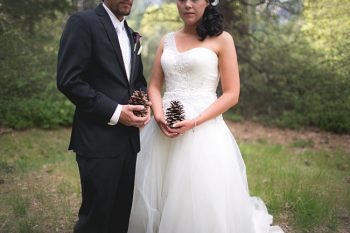 Yosemite bride and groom hold pinecones
