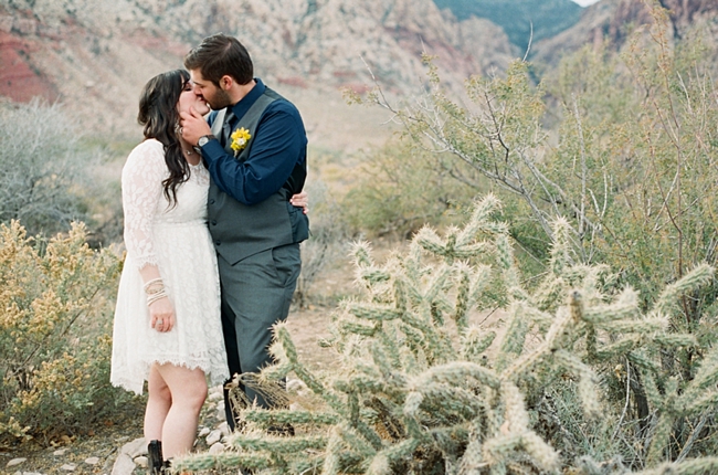 bride and groom stand near a cholla bush photo by Gaby J Photography