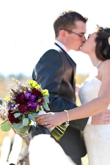 14a-Devils-Thumb-Ranch-wedding-Becky-Young Photography-bouquet-on-fence-kiss