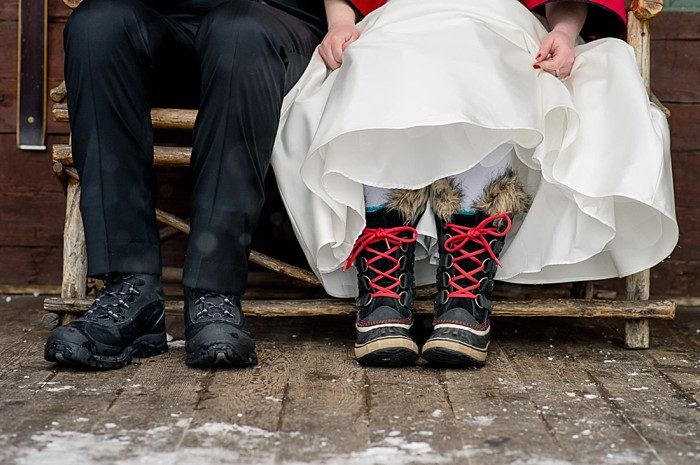 Snow boots with red laces under a wedding dress at a winter elopement