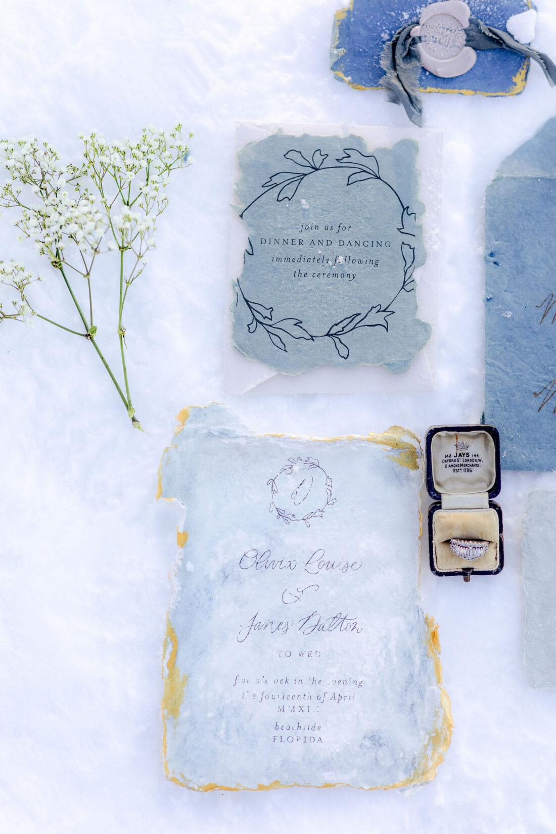 invitation with ring in box laying in snow