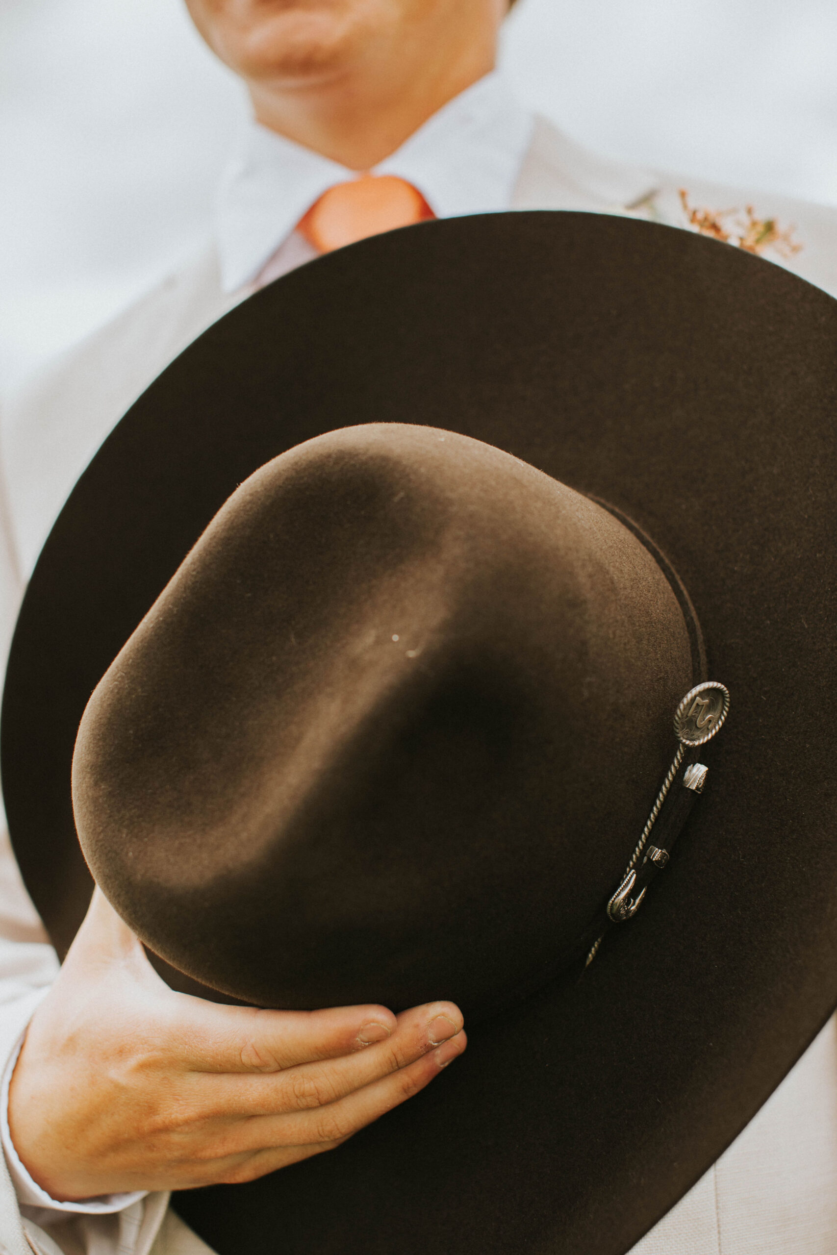 groom holding a chocolate cowboy hat
