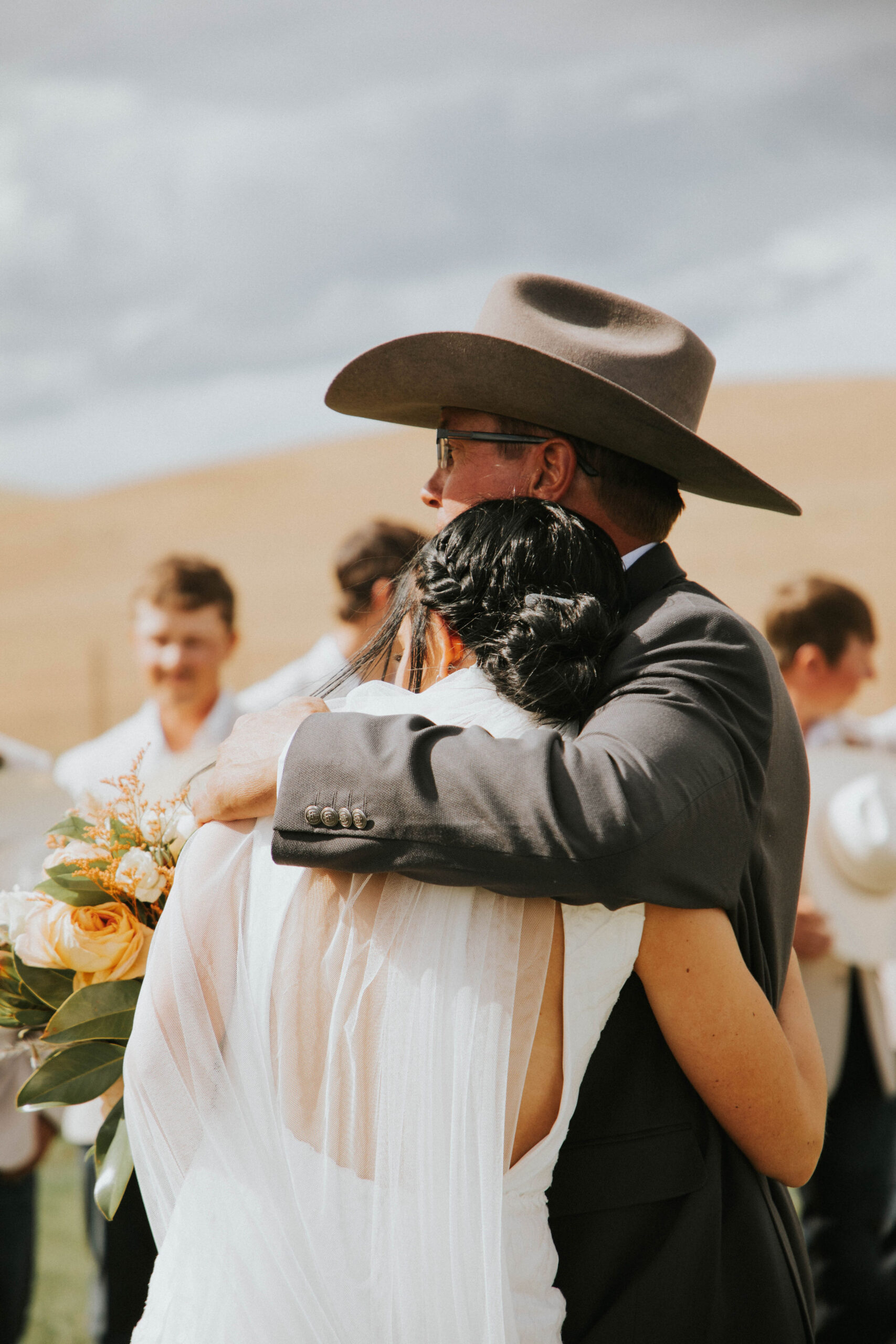 bride and dad hugging in a rustic mountain wedding