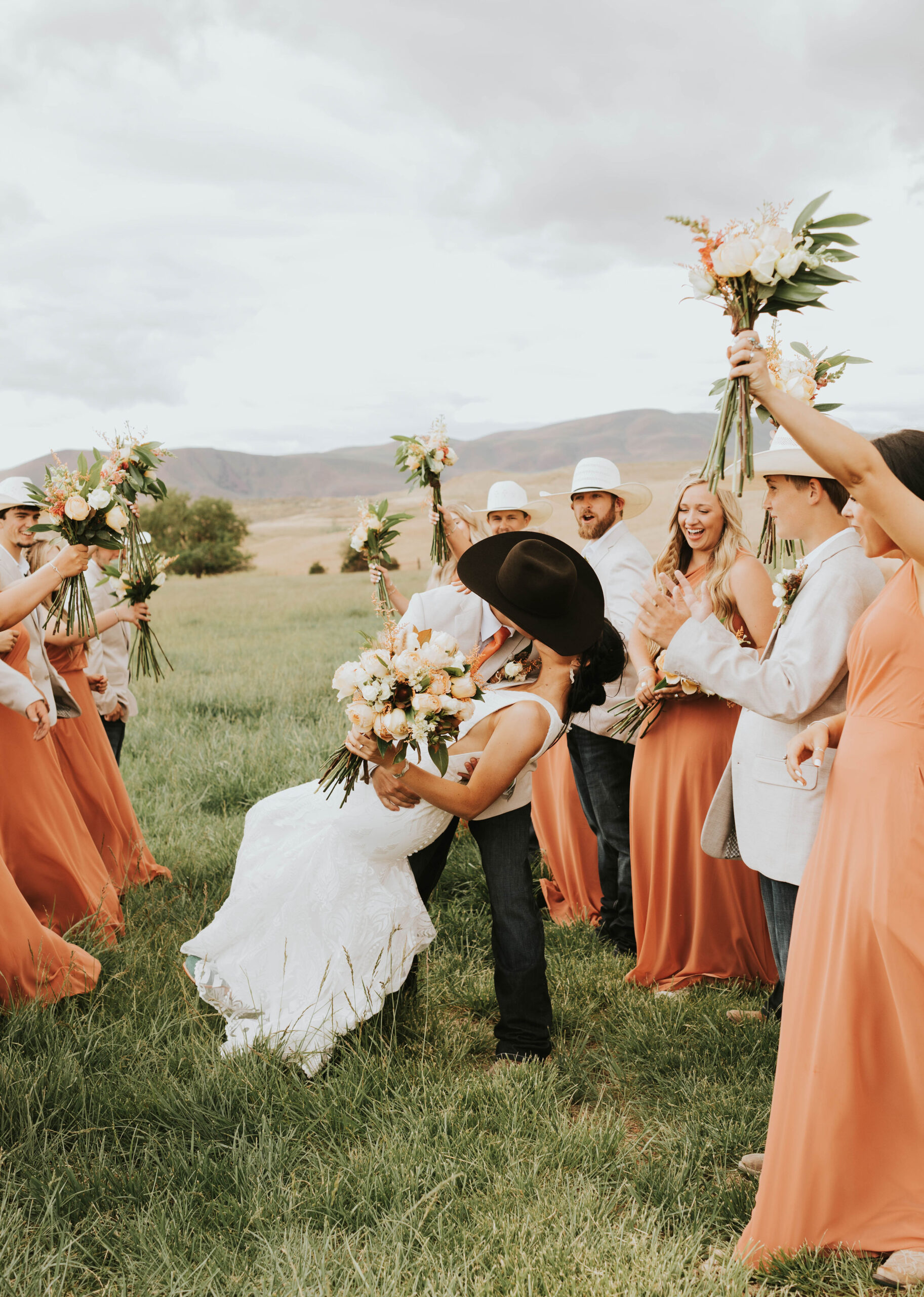 bride and groom kissing in the middle of the aisle in a rustic mountain wedding
